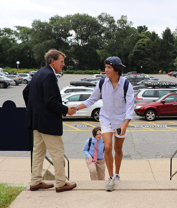 Head of School greets student arriving on campus