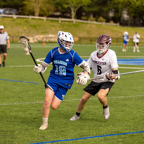 boys lacrosse player being guarded by defender
