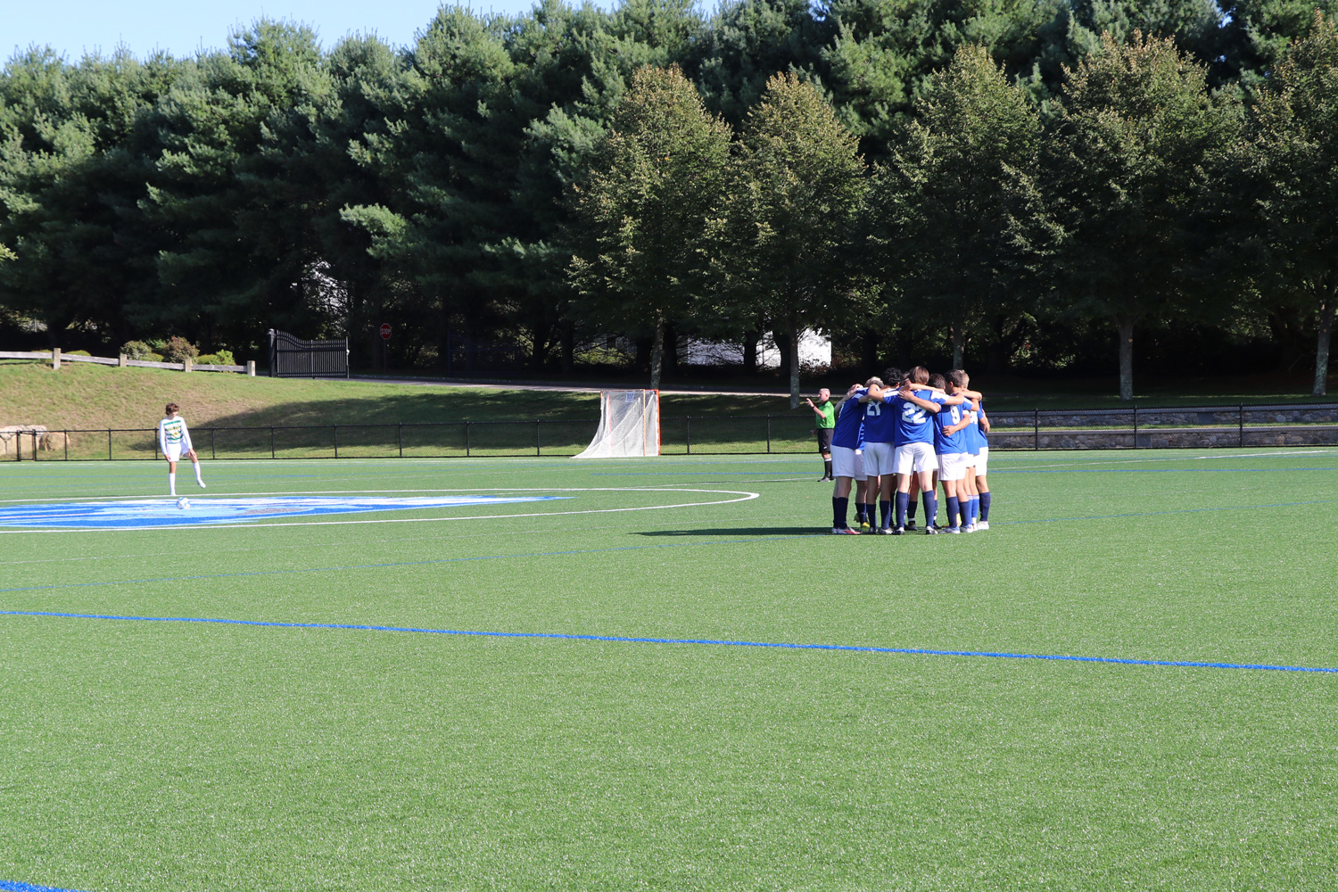soccer team huddle on turf field before game