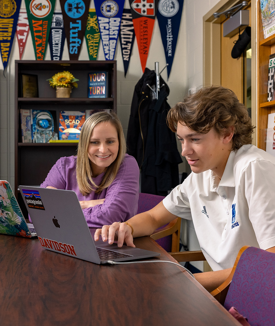 college advisor helping student on laptop