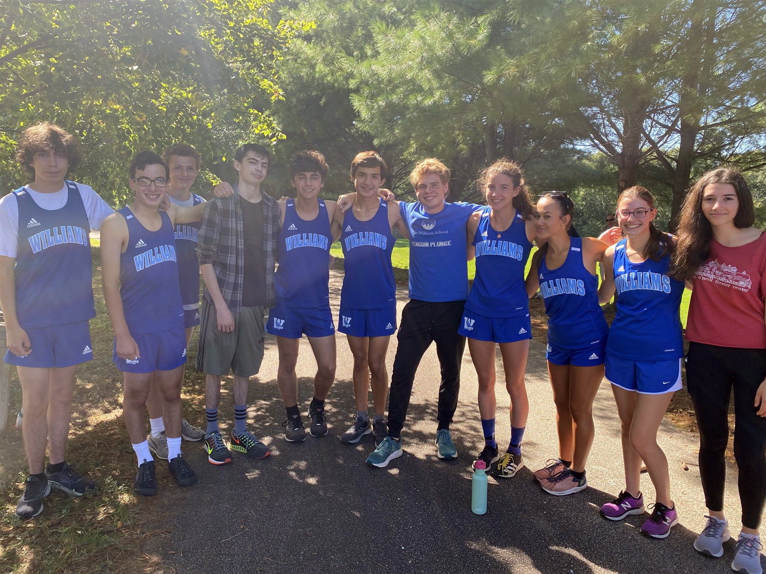cross country team posing on trail