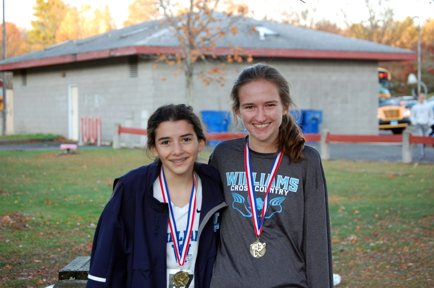 two cross country runners wearing medals around necks