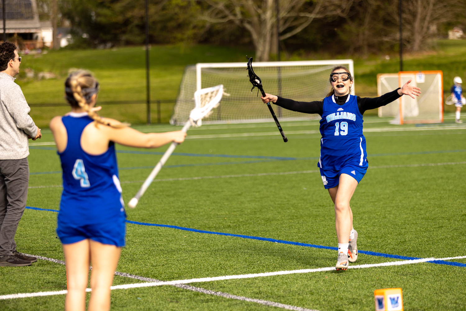 Girl lacrosse players running to hug each other