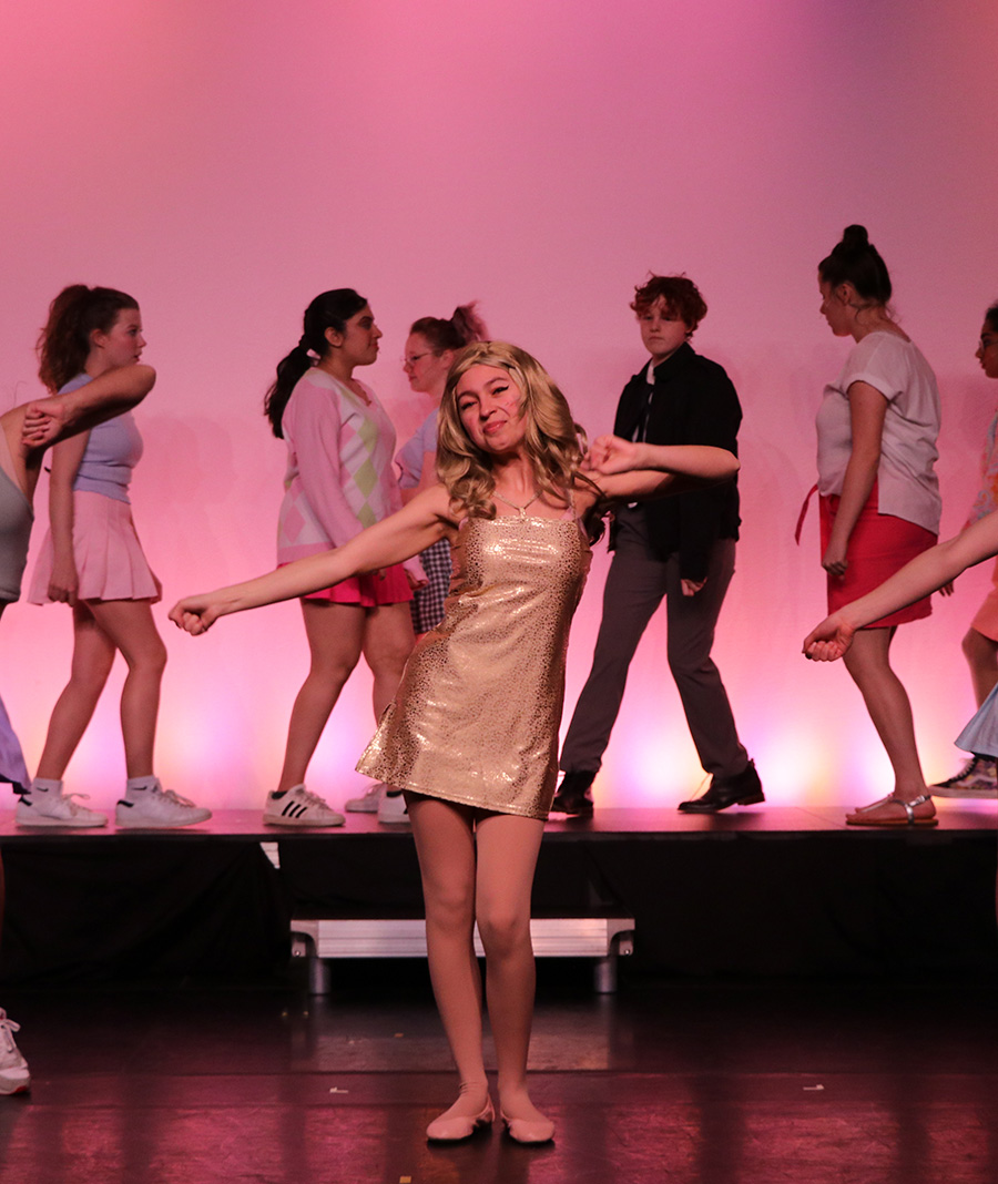 student performing on stage during legally blonde production at school