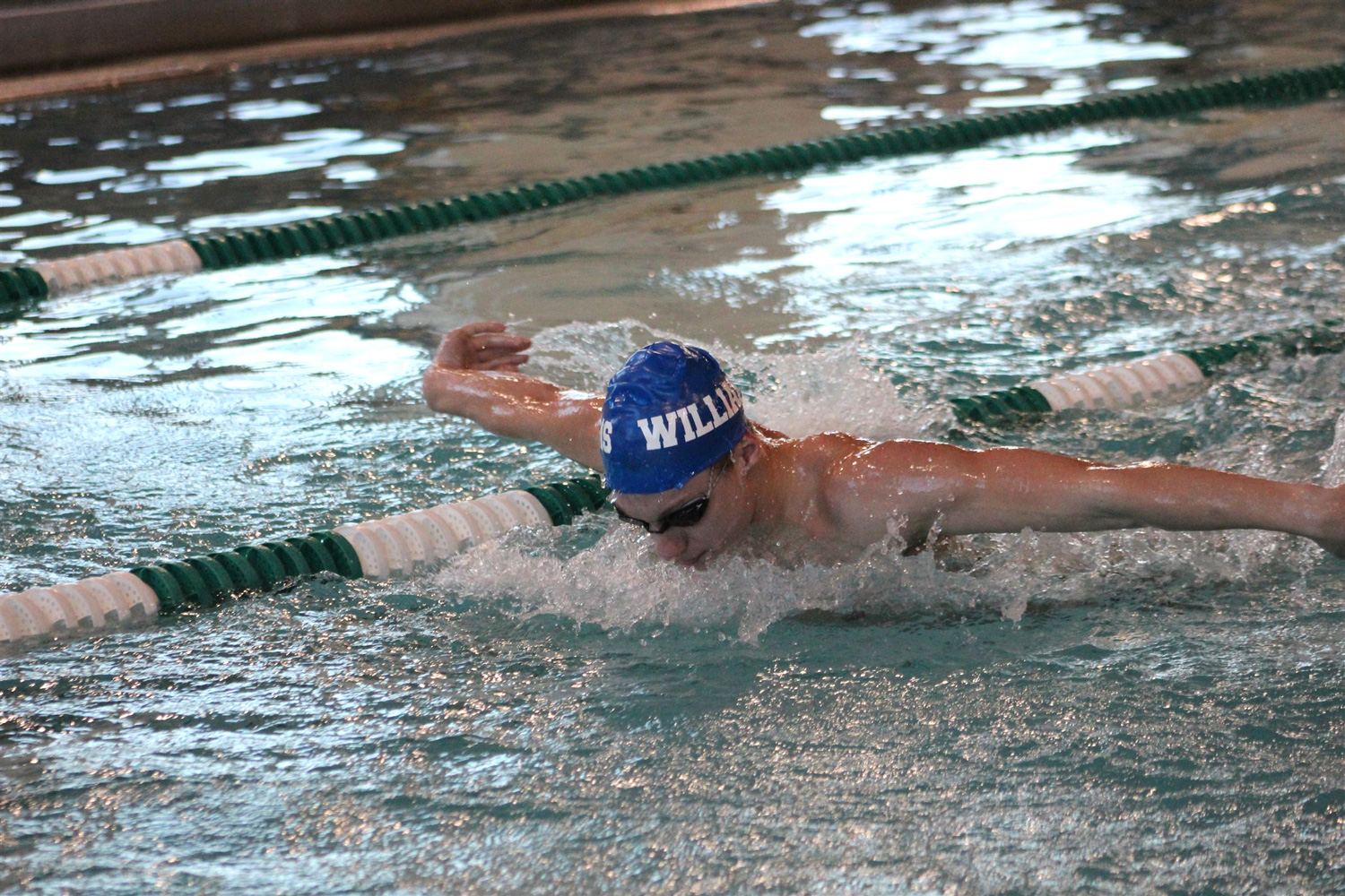 student swimmer doing butterfly stroke in pool
