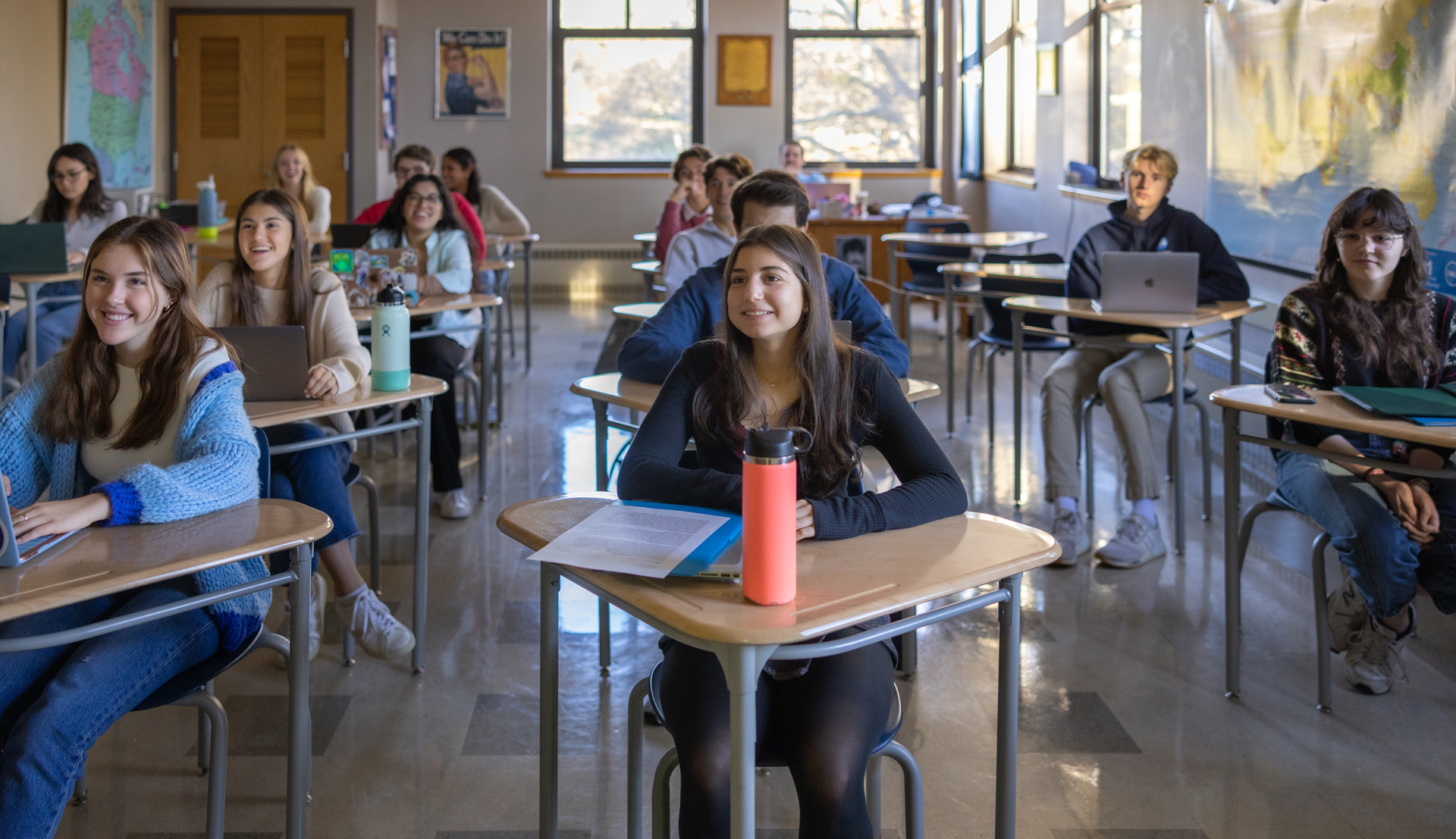students smiling at their desks during class