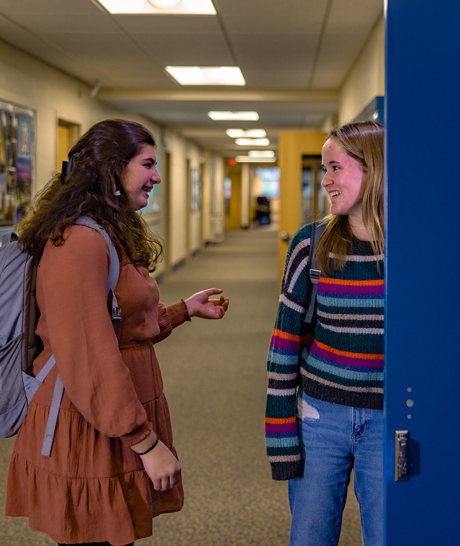 two student friends talking at locker