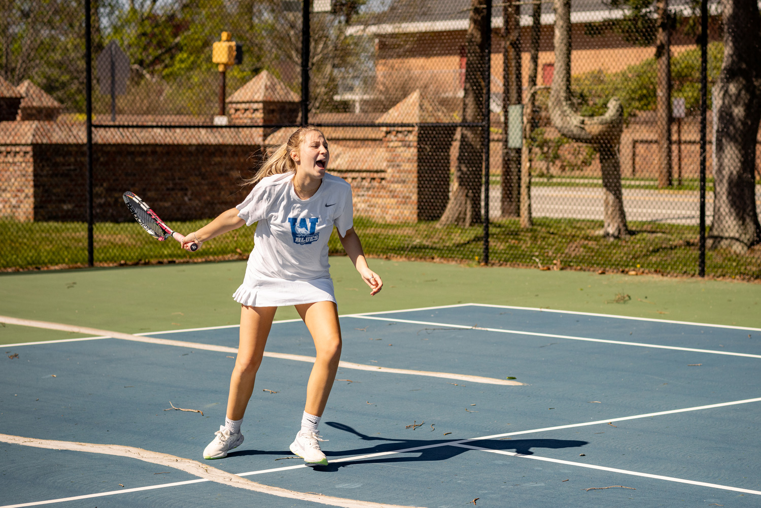 student tennis player swinging on court