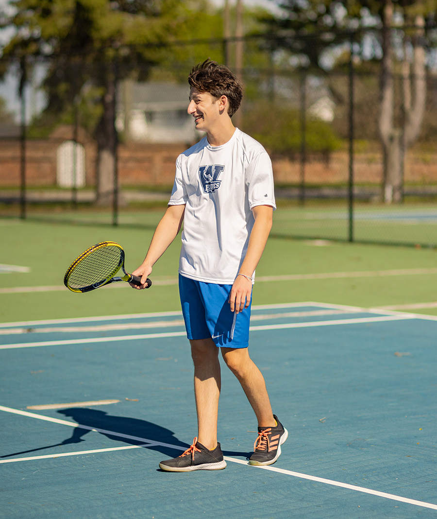 student tennis player smiling on court