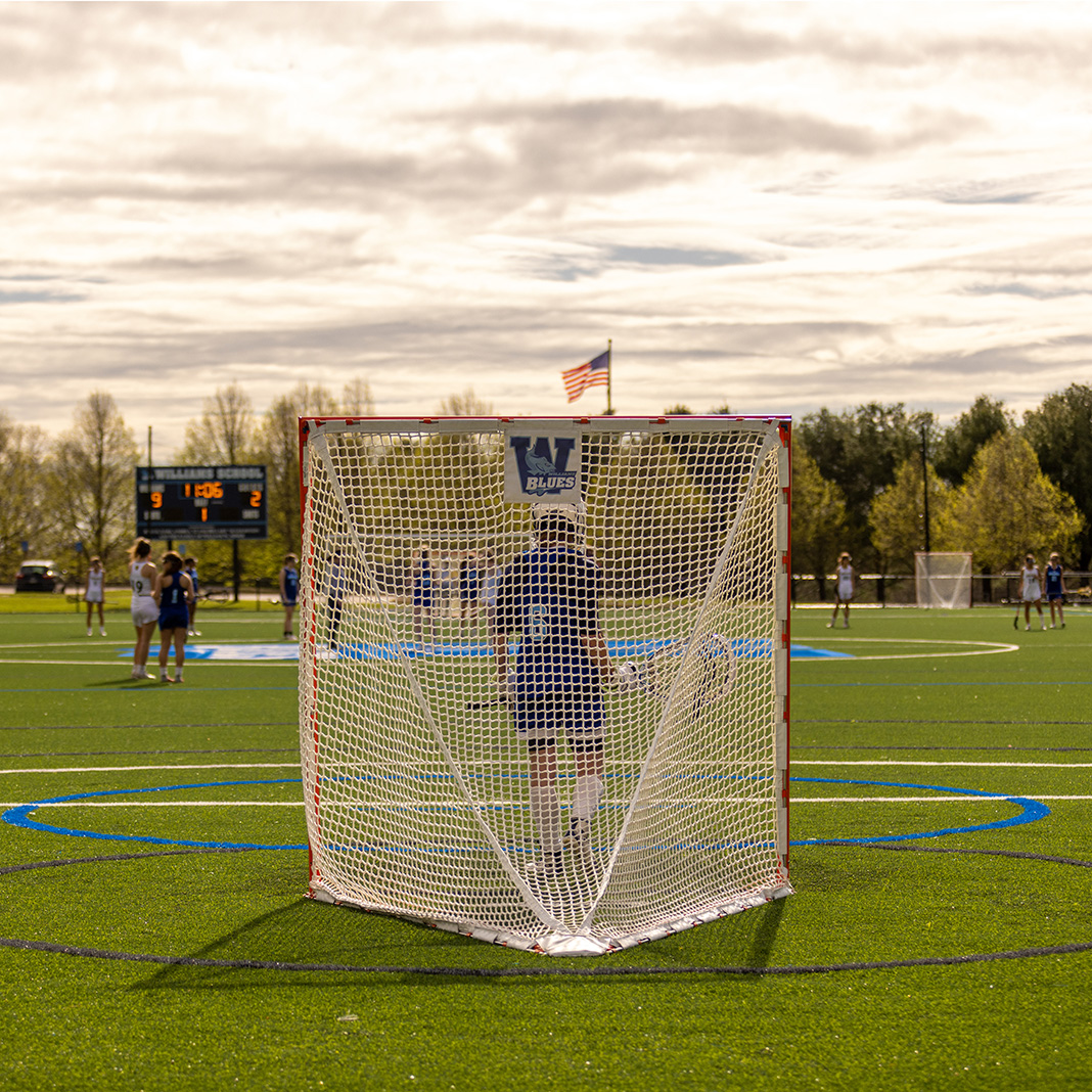 Angle from behind the goal net during lacrosse game
