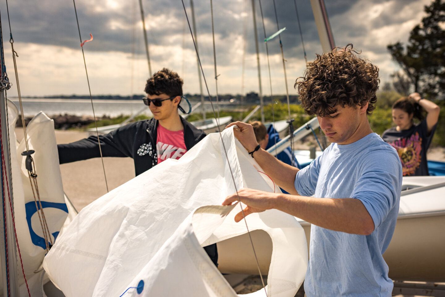 Williams sailing students unfurling sail at the marina