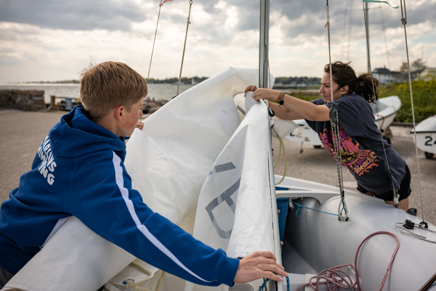 Williams sailing students attach the sail to their boat at the marina