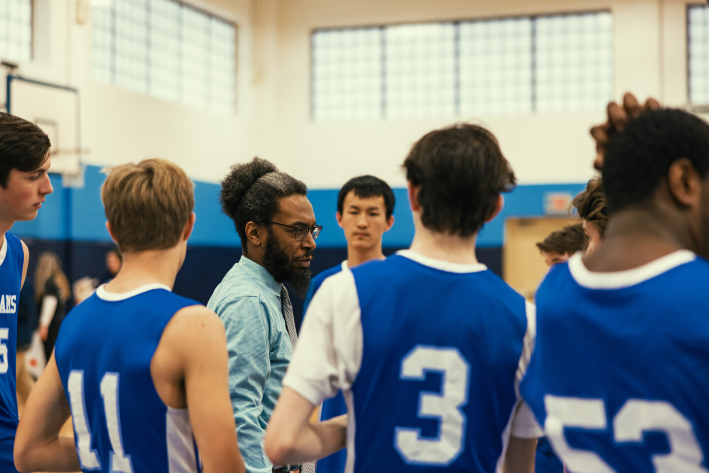 Boys basketball coach talks to players during a game