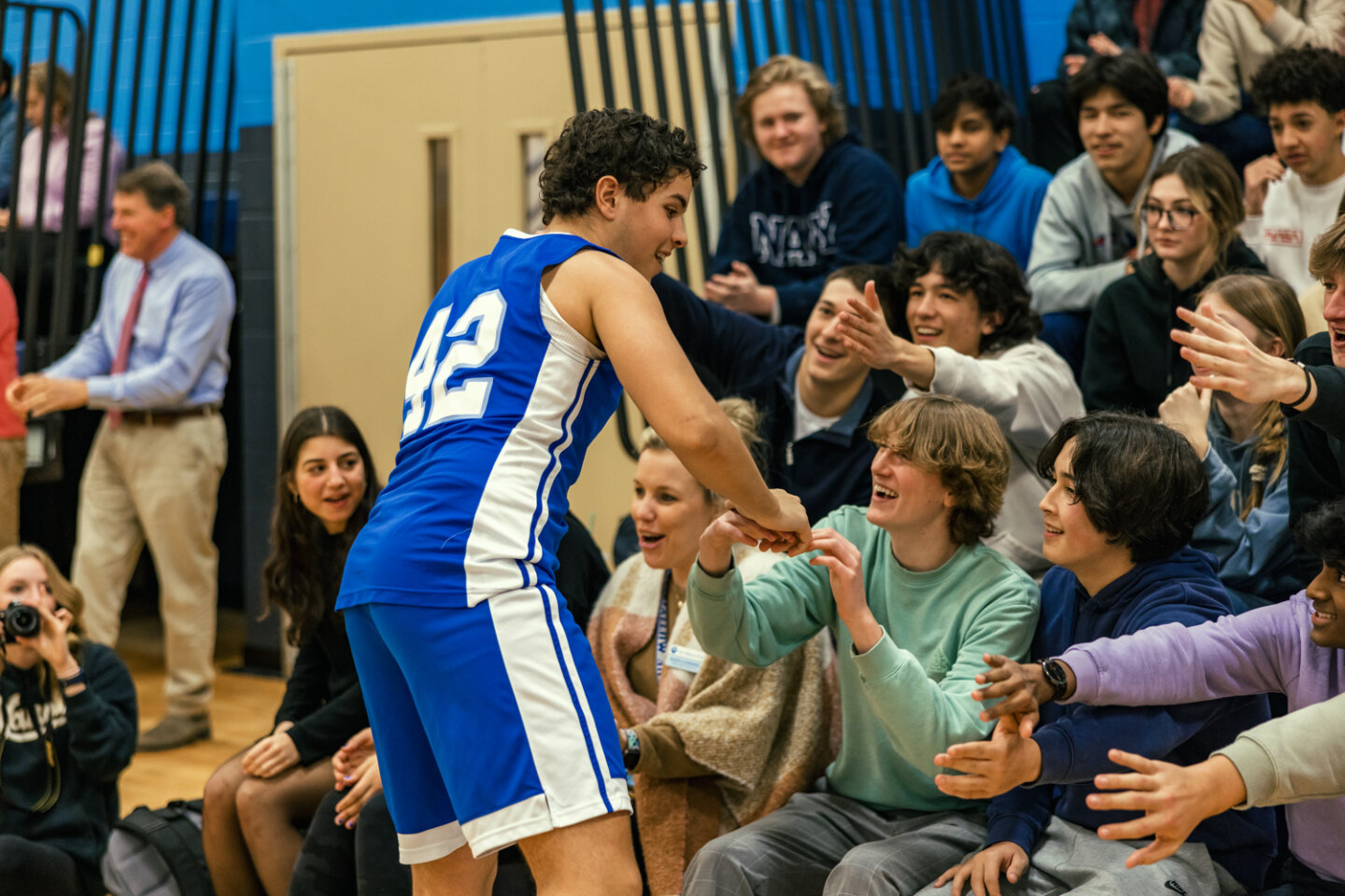 Boys basketball player greets spectators in the stands