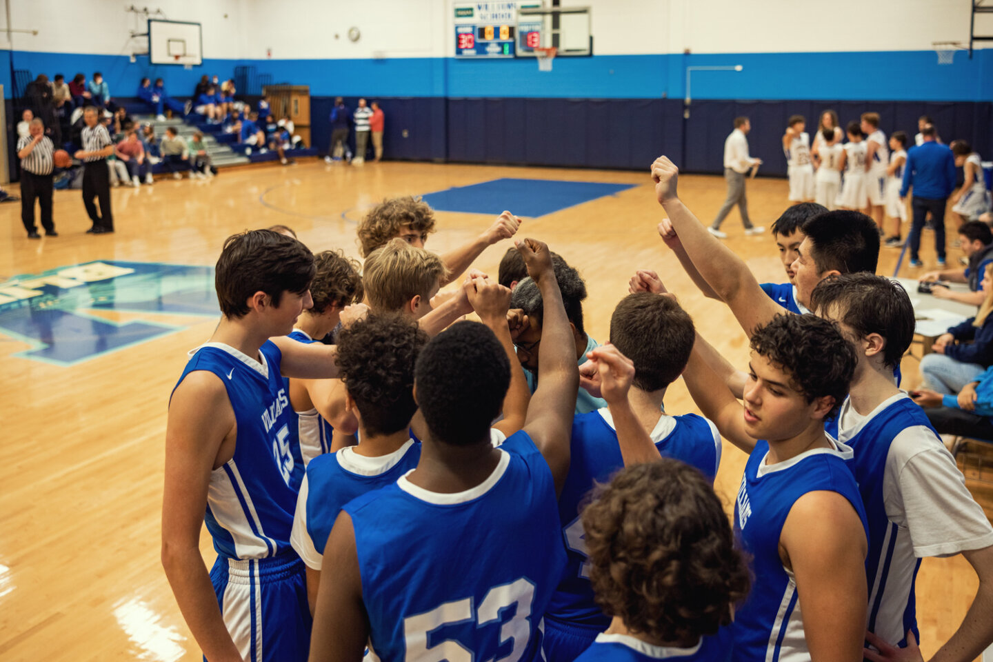 Boys basketball team huddles around coach during game