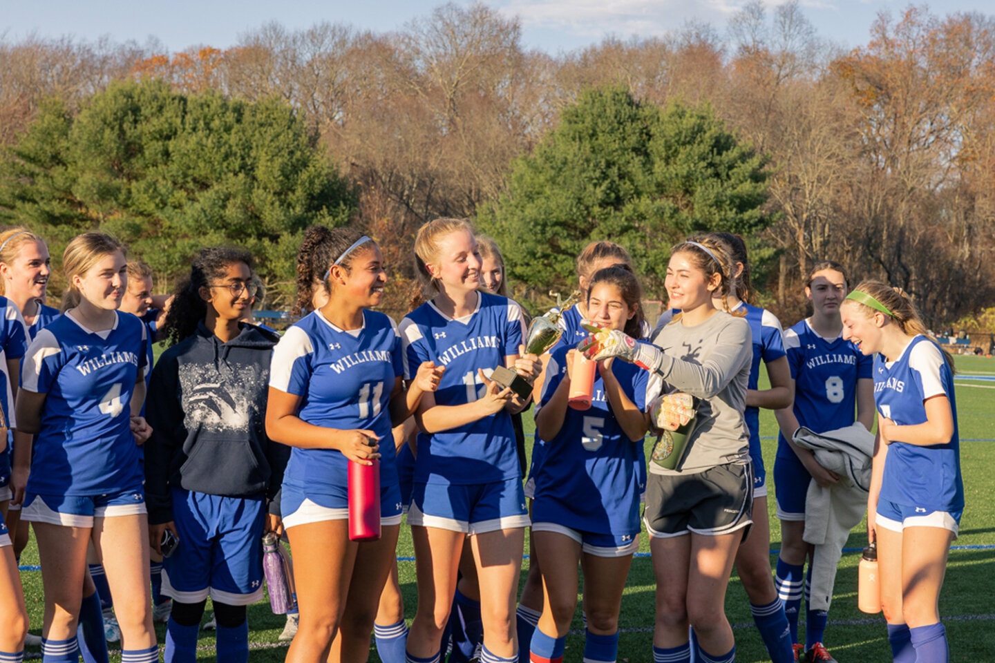 Girls soccer team celebrates win with trophy