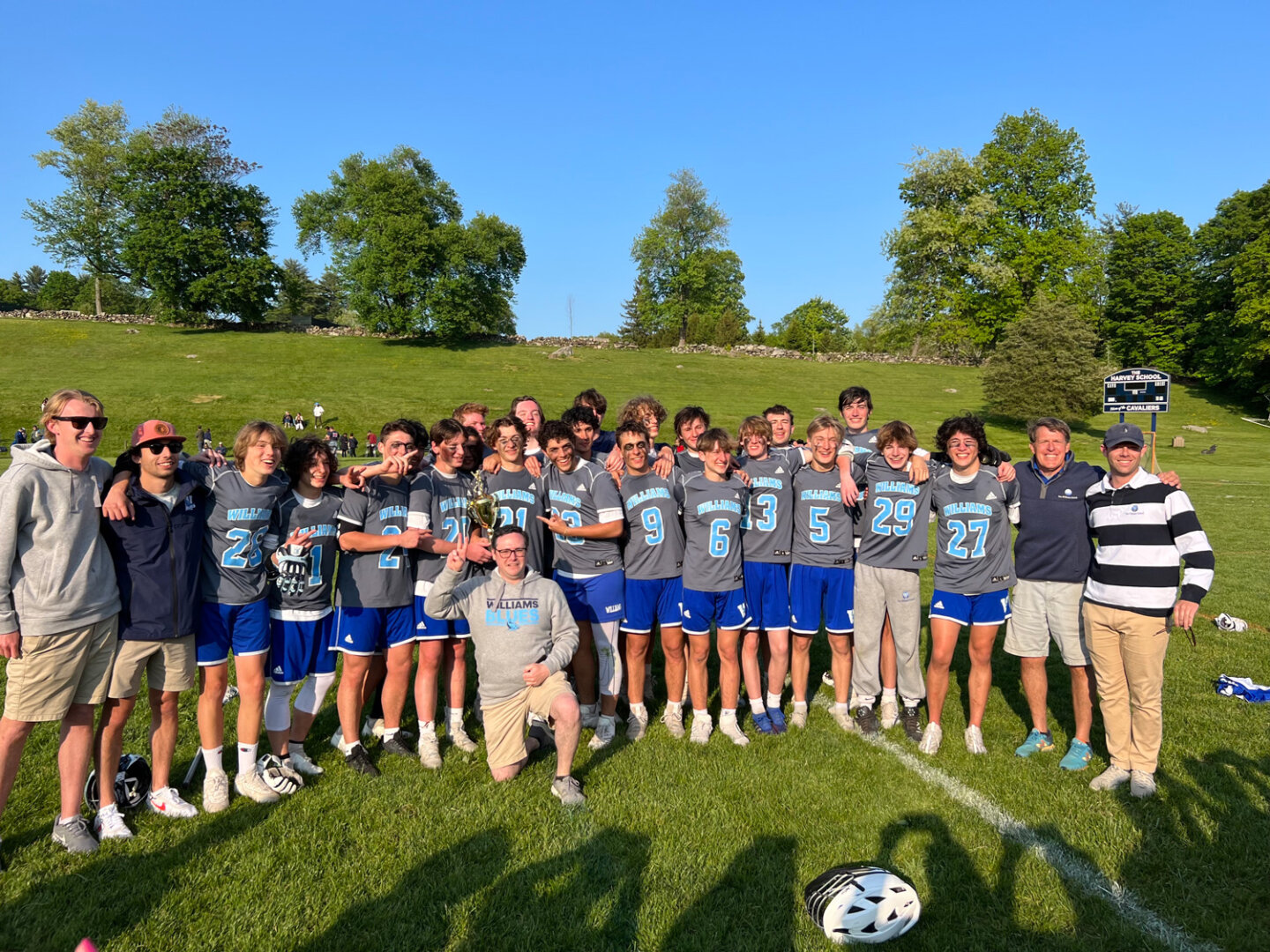 Williams School boys lacrosse team and coaches pose on lacrosse field