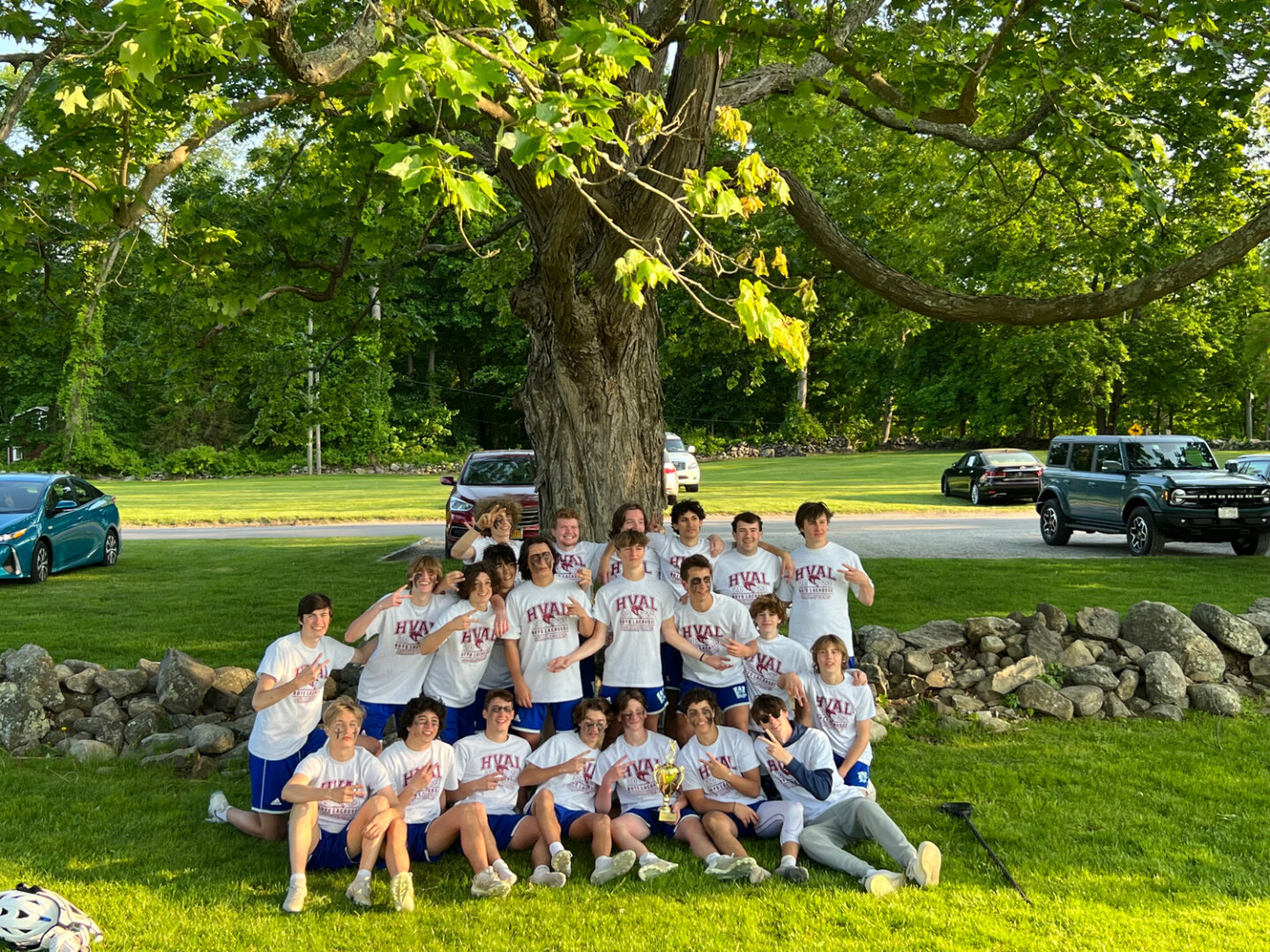 Williams School boys lacrosse team pose in front of a large tree in their HVAL shirts