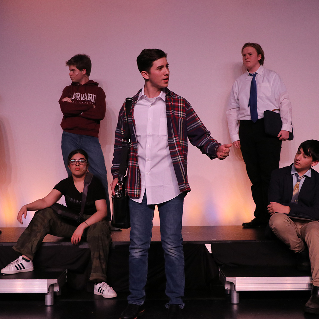 Williams School drama student acting in Legally Blonde with four students on set in the background