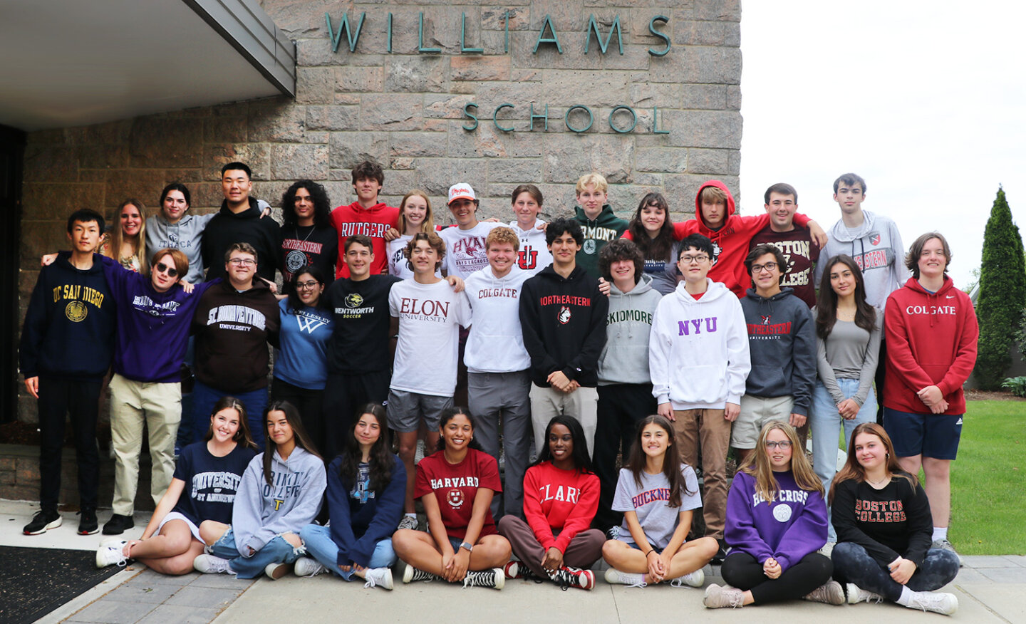 Williams School students pose in front of the school building in the clothes of their favorite colleges